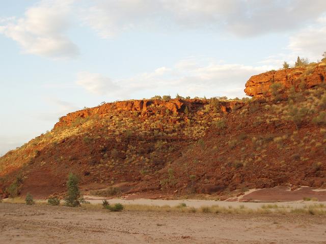 red cliffs lit beautifully at sunset along the side of the dry fink river bed