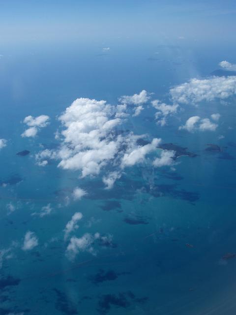 looking down on the whitsunday islands through fluffy clouds