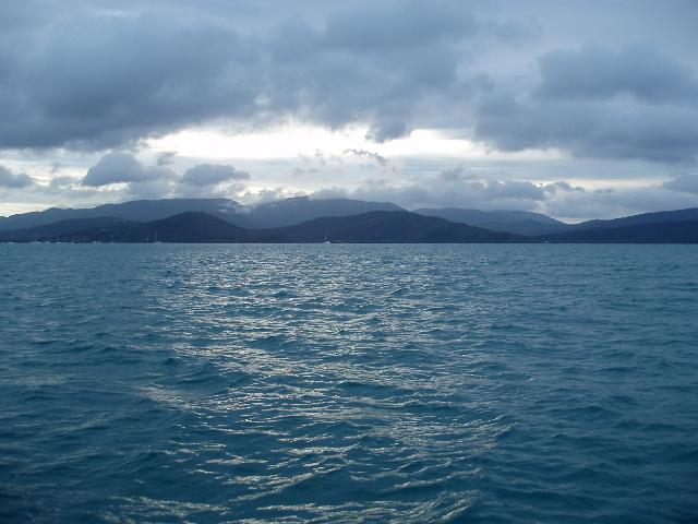 scattered clouds and moored yachts, a panoramic view of pioneer bay and surrounding coastline,