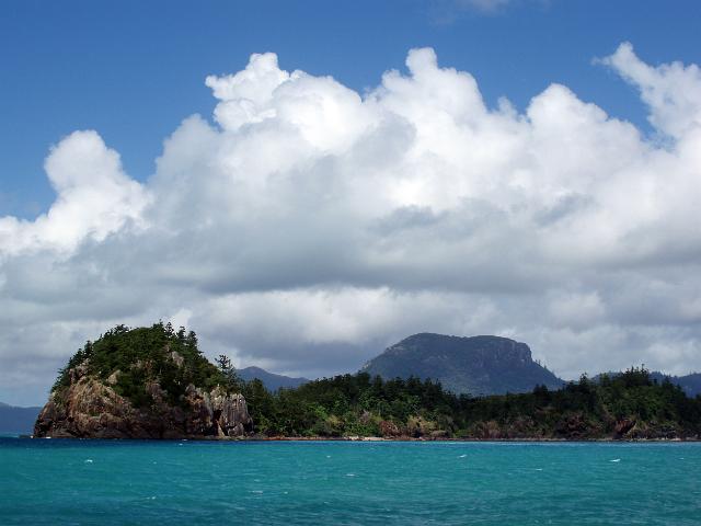 looking across the water towards a rocky penninsula and whitsunday island to the rear