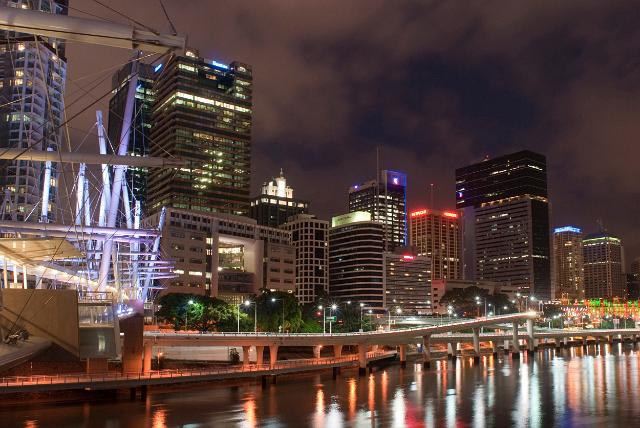 Central Brisbane at night with a waterfront view of the illuminated buildings reflected in the calm water below