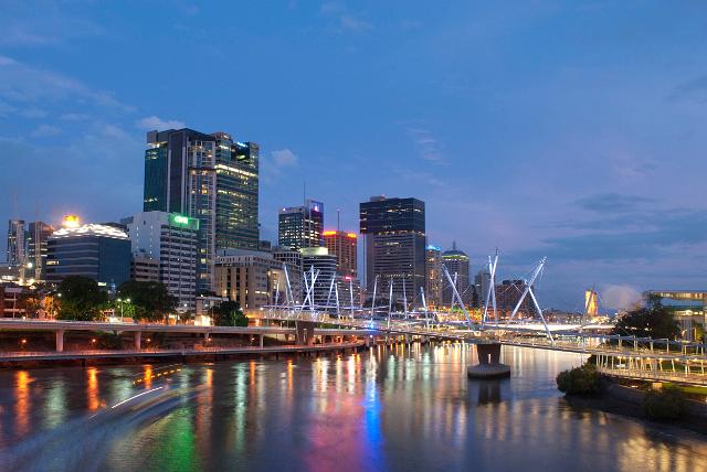 Kurilpa Bridge, Brisbane at twilight as it crosses the Brisbane River with the colourful lights from the high rise buildings in the CBD reflected in the water