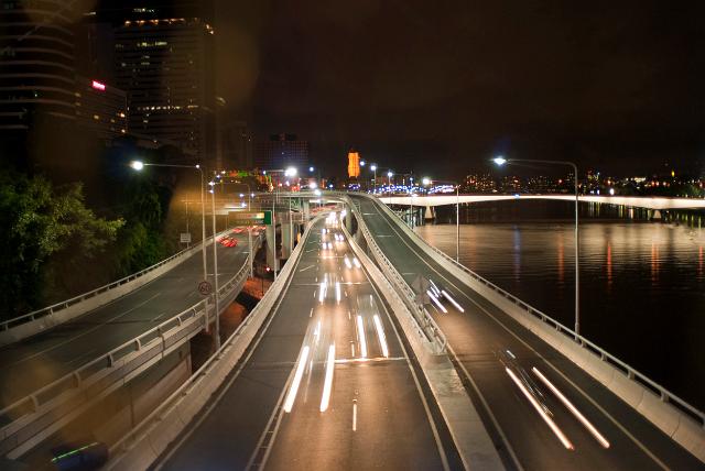 Traffic on Coronation Drive at night driving along the edge of the Brisbane River towards the city in Brisbane, Queensland, Australia