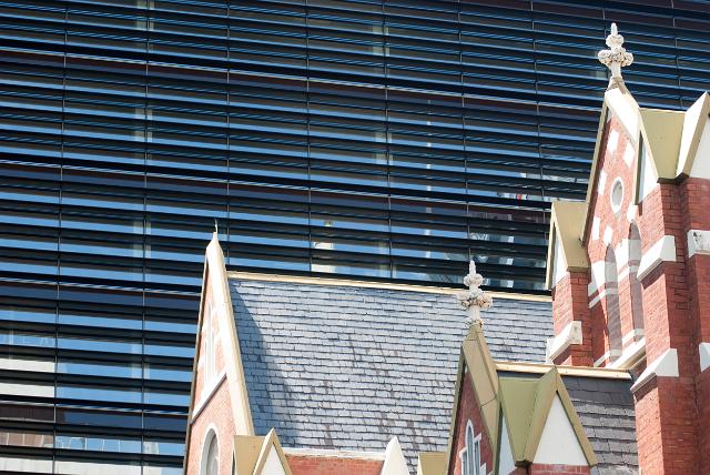 roof of albert street church in central brisbane dwarfed by a large office building in the background
