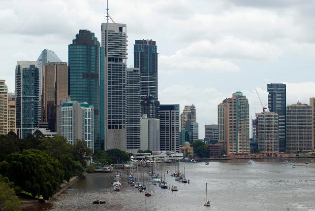 Highrise Brisbane, Australia with a view of the small boats moored alongside the river banks against a backdrop of modern skyscrapers in the CBD