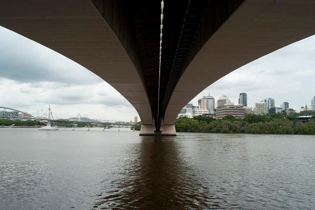View from underneath looking along the span of the Victoria Bridge in Brisbane, Australia as it crosses the Brisbane River with the city visible on the far bank