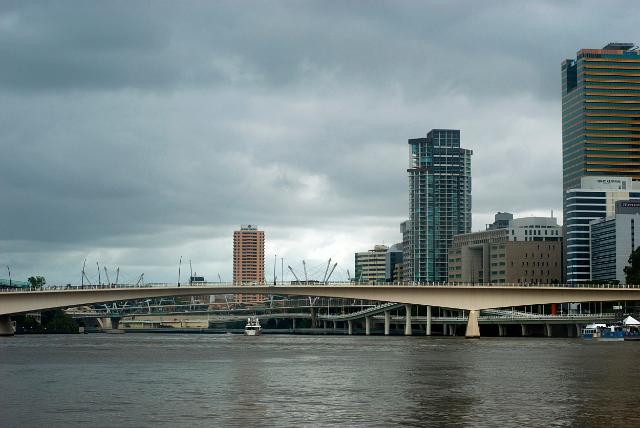 Victoria Bridge in Brisbane, Australia crossing the Brisbane River with the buildings of the city centre on the skyline against grey clouds