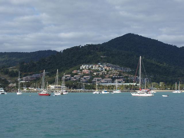 a view of airlie beach and boats moored along the shoreline