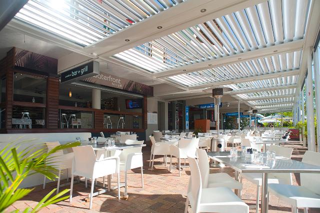 Open-air restaurant on Airlie esplanade with seating and tables on a covered patio in Queensland, Australia