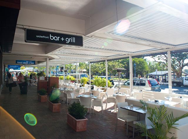 Airlie esplanade dining with an open-air restaurant on a covered porch overlooking a street in Airlie Beach, Queensland, Australia