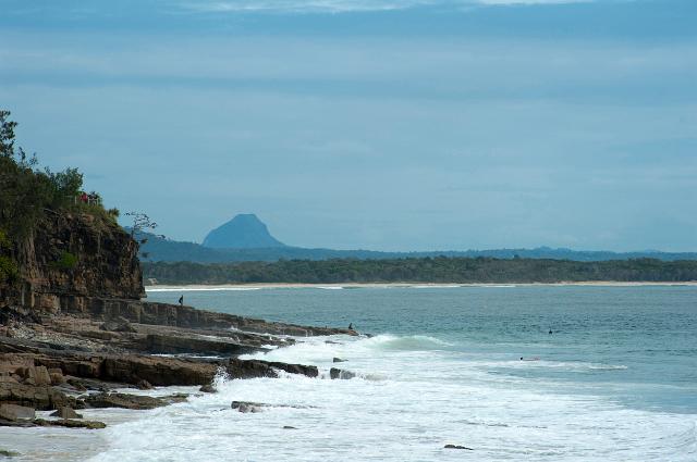 View along the rocky coastline and ocean to Mt Cooroora, Queensland, Australia in the distance