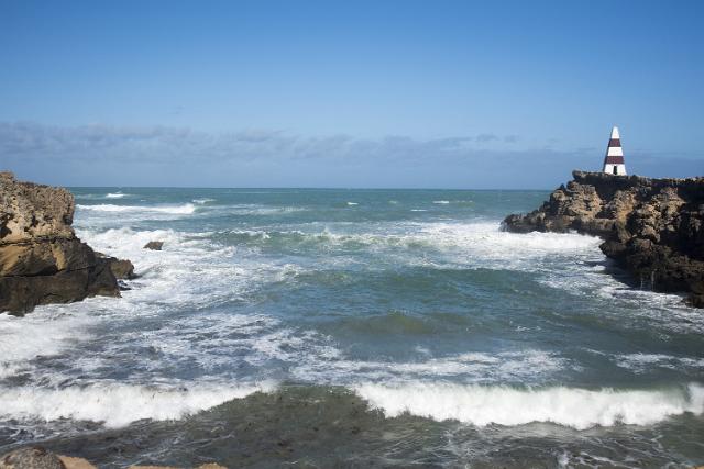 Guichen Bay with waves crashing on the coastal rocks and cliffs and the Robe Obelisk, South Australia in a travel and tourism concept