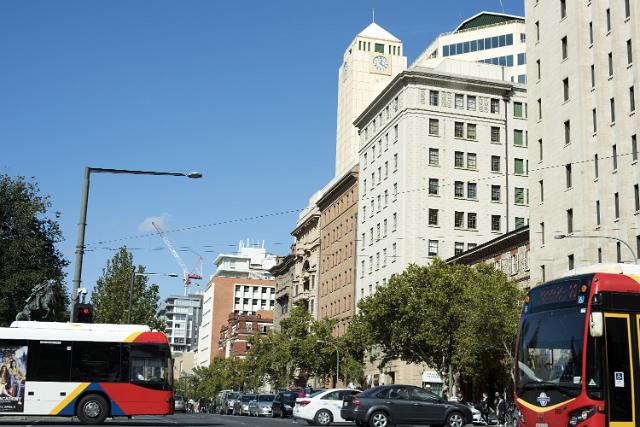 Busy street scene in Adelaide CBD in South Australia with buses and cars in front of high-rise buildings