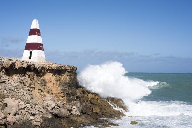 Waves pounding the cliffs below the Robe Obelisk, South Australia causing erosion which has rendered access to the landmark dangerous