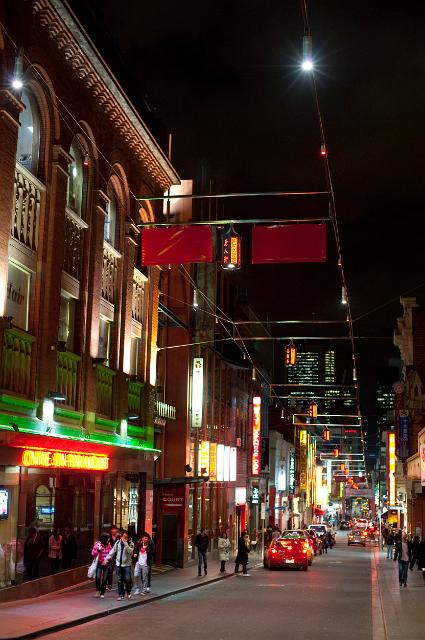 Street scene in Littlle Bourke Street, China Town, Melbourne, Australia at night with bright neon lights, pedestrians and parked cars