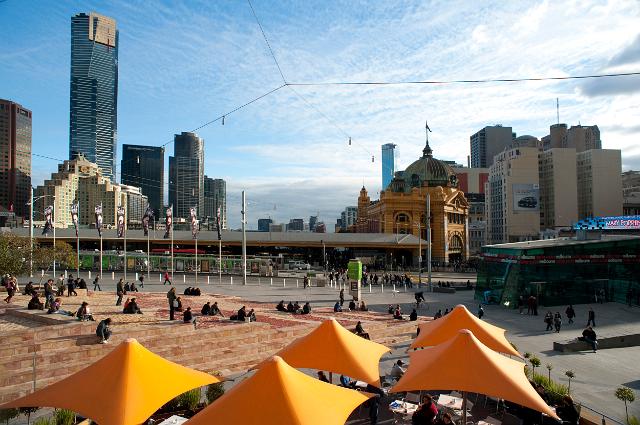 Federation Square, Melbourne, or Fed Sqare as it is locally known, with a view across colourful umbrellas and relaxing people to the highrise buildings of the CBD