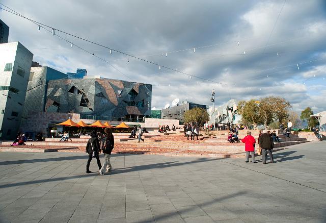 People walking through Federation Square, or Fed Square in Melbourne , a civil centre and cultural meeting point in the CBD